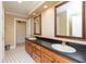 Bathroom featuring double sinks, framed mirrors, and classic tile flooring at 8535 Washington Blvd, Indianapolis, IN 46240