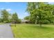 Sprawling brick home with lush greenery, manicured lawn and long drive at 8535 Washington Blvd, Indianapolis, IN 46240