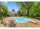In-ground pool with an outdoor patio area and chairs and a well-maintained yard at 8535 Washington Blvd, Indianapolis, IN 46240