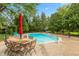 In-ground pool with an outdoor dining area and chairs and a well-maintained yard at 8535 Washington Blvd, Indianapolis, IN 46240