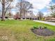 Lovely ranch-style home with a well-kept lawn, mature trees, and a long gravel driveway leading to a two-car garage at 8621 Manderley Dr, Indianapolis, IN 46240