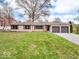 Charming single-story home with a well-manicured lawn, two-car garage, and stone facade at 8621 Manderley Dr, Indianapolis, IN 46240