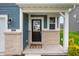 Close-up of the front door with black hardware, light brick accents, and a welcoming 'oh hello' doormat at 8694 Moyer Pl, Pendleton, IN 46064