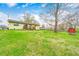 Large backyard with green grass, good sunlight exposure, a wooden deck, shed and some trees at 9055 Panorama Ct, Indianapolis, IN 46234