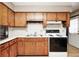 The kitchen features wooden cabinets, a white countertop, and is equipped with essential appliances, like a microwave and stove at 9055 Panorama Ct, Indianapolis, IN 46234