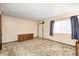 Spacious living room featuring neutral walls, patterned carpet, large window and storage cabinet for comfortable living at 9055 Panorama Ct, Indianapolis, IN 46234
