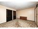 Spacious living room features neutral walls, patterned carpet, storage cabinet and dark stained closet doors at 9055 Panorama Ct, Indianapolis, IN 46234