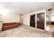 Comfortable living room featuring neutral walls, patterned carpet, brown sofa and dark stained doors at 9055 Panorama Ct, Indianapolis, IN 46234