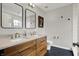 Modern bathroom with a double vanity, stylish mirrors, and sleek black and white tiling at 967 Orlando St, Carmel, IN 46032