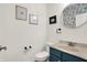 Stylish half bathroom featuring modern fixtures, decorative wall art, and a unique round mirror at 967 Orlando St, Carmel, IN 46032