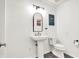 Bathroom featuring a pedestal sink, toilet, modern fixtures, and simple decor, emphasizing cleanliness and style at 967 Orlando St, Carmel, IN 46032