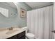 Neutral bathroom with a round mirror over the vanity and a shower with a white curtain at 967 Orlando St, Carmel, IN 46032