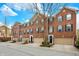 Charming red brick townhomes with attached garages, black shutters, and inviting front doors under a bright sky at 967 Orlando St, Carmel, IN 46032