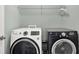 Functional laundry room with modern white and black appliances, and convenient overhead shelving at 967 Orlando St, Carmel, IN 46032