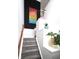 Carpeted stairway with white walls and trim, contrasted by black accent wall and colorful artwork at 967 Orlando St, Carmel, IN 46032