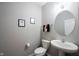 Neat half bathroom featuring a pedestal sink, a modern round mirror, and neutral walls at 9770 Blue Violet Dr, Noblesville, IN 46060