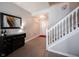 Bright hallway with staircase, modern lighting, and a stylish wine rack at 9770 Blue Violet Dr, Noblesville, IN 46060
