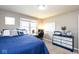 Comfortable bedroom with a blue quilt, a desk with a computer and white and blue dresser at 9812 Logan Ln, Fishers, IN 46037