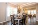 Dining room with a wood table and 6 chairs, chandelier and a living room view at 9812 Logan Ln, Fishers, IN 46037