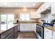 Well-lit kitchen with granite countertops, stainless steel appliances, white cabinetry, and dark wood flooring at 9812 Logan Ln, Fishers, IN 46037