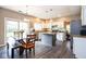 Modern kitchen and dining area with stainless steel appliances, granite counters, island, and hardwood floors at 9812 Logan Ln, Fishers, IN 46037