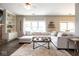 Cozy living room featuring a brick fireplace, built-in shelving, large windows, and comfortable, neutral-toned furniture at 9812 Logan Ln, Fishers, IN 46037
