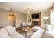 Comfortable living room with brick fireplace, built-in shelving, soft lighting, and a cozy sectional sofa at 9812 Logan Ln, Fishers, IN 46037