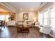 Living room with a tan sofa, two chairs, large picture windows and a dining room view at 9812 Logan Ln, Fishers, IN 46037