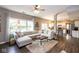 Inviting living room featuring a plush sectional sofa, wood floors and an open floorplan to the kitchen at 9812 Logan Ln, Fishers, IN 46037