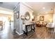 Open-concept foyer with stylish console table leading to a cozy living room with a comfortable couch at 9812 Logan Ln, Fishers, IN 46037