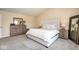 Neutral colored main bedroom with a tufted headboard, gray carpet, and plenty of natural light at 9812 Logan Ln, Fishers, IN 46037