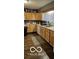 Functional kitchen features wood cabinets, durable vinyl flooring, and sufficient counter space for meal preparation at 1006 Columbia Ave, Alexandria, IN 46001