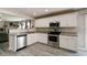 Updated kitchen features stainless steel appliances, granite countertops, and white cabinetry at 10597 Cyrus Dr, Indianapolis, IN 46231