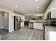 Spacious kitchen with stainless steel refrigerator, white cabinets, and granite countertops at 10597 Cyrus Dr, Indianapolis, IN 46231