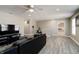 Large living room area with black leather couch, ceiling fan and grey, wood-look vinyl flooring at 10597 Cyrus Dr, Indianapolis, IN 46231