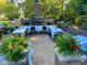 A well decorated backyard patio with a long table set for a party with lush greenery and outdoor fireplace at 1060 Cape Coral Dr, Cicero, IN 46034