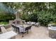 Relaxing backyard patio with an outdoor fireplace and comfortable seating area surrounded by lush greenery at 1060 Cape Coral Dr, Cicero, IN 46034