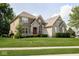 Charming two-story home with a well-manicured lawn and beautiful stone and brick facade, featuring a striking red front door at 1060 Cape Coral Dr, Cicero, IN 46034