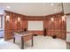 Finished basement with a foosball table, media area, and rich wood paneling at 10628 Walnut Creek W Dr, Carmel, IN 46032