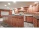 Finished basement with custom bar featuring rich wood cabinetry, granite counters, slate flooring, and under cabinet lighting at 10628 Walnut Creek W Dr, Carmel, IN 46032