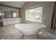 Inviting bathroom featuring a luxurious freestanding tub near a window, complemented by a spacious vanity area at 10628 Walnut Creek W Dr, Carmel, IN 46032