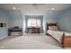 Spacious bedroom with blue walls, carpeted floors, a piano and a desk at 10628 Walnut Creek W Dr, Carmel, IN 46032
