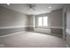 Bright bedroom features chair rail, neutral carpet, window with bench, and a ceiling fan at 10628 Walnut Creek W Dr, Carmel, IN 46032