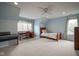 Spacious bedroom with blue walls, carpeted floors, a piano and a desk at 10628 Walnut Creek W Dr, Carmel, IN 46032