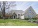 Beautiful home featuring stone and brick exterior, manicured lawn and professional landscaping at 10628 Walnut Creek W Dr, Carmel, IN 46032