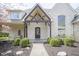 Charming covered front porch with brick and timber detailing and manicured landscaping at 10628 Walnut Creek W Dr, Carmel, IN 46032