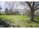 Beautifully landscaped front yard with mature trees and lush green grass of the lovely brick home at 10628 Walnut Creek W Dr, Carmel, IN 46032