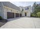 Spacious three-car garage with concrete driveway and stone veneer at 10628 Walnut Creek W Dr, Carmel, IN 46032