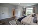 Airy main bedroom with wood floors, a large window, and double doors to the main bathroom and closet at 10628 Walnut Creek W Dr, Carmel, IN 46032