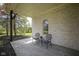 Covered patio with brick wall, stone floor, arched window, and outdoor furniture at 10628 Walnut Creek W Dr, Carmel, IN 46032